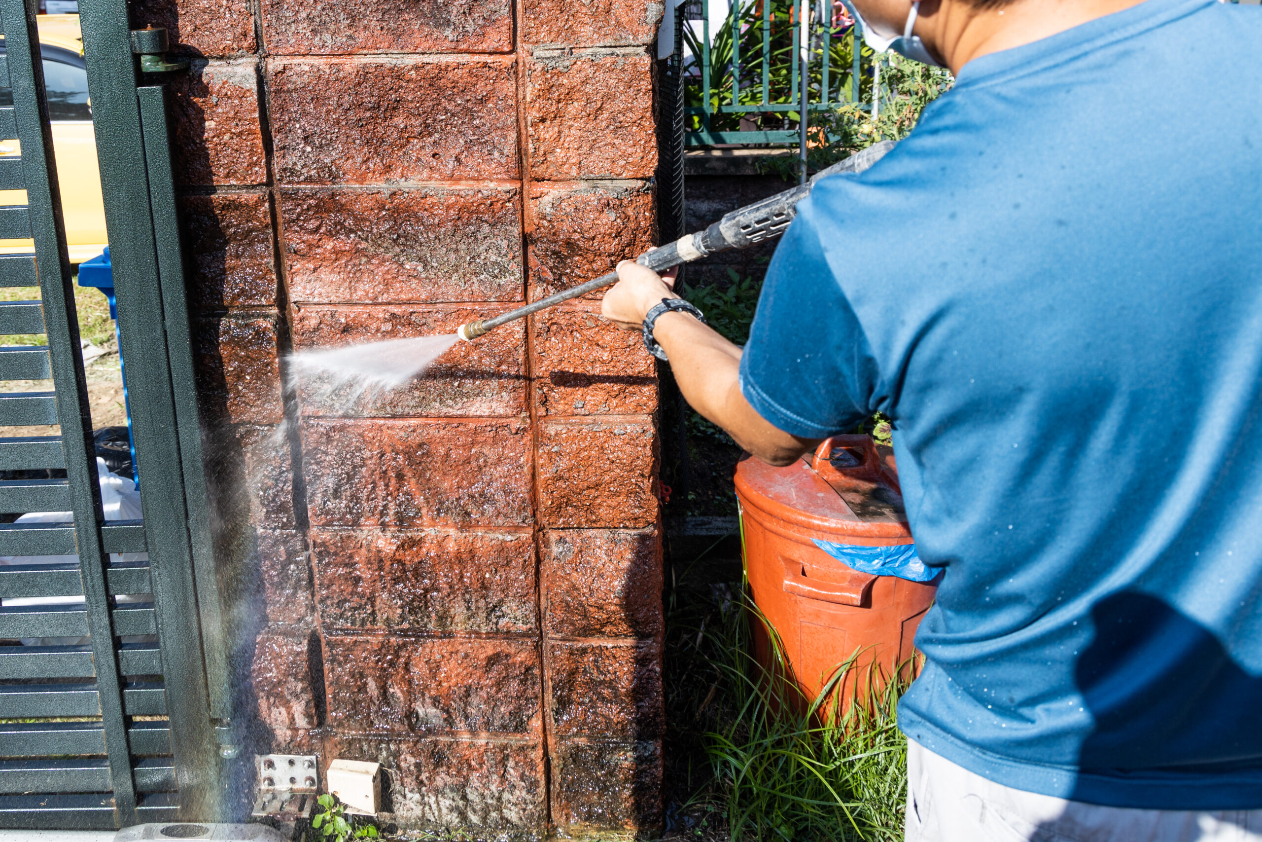 Worker using high pressure water jet spray gun to wash and clean away dirty wall with moss Pressure house and concrete walls in Las Vegas Nevada